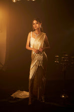 Load image into Gallery viewer, Shop Designer Metallic Shimmer Slit Saree &amp; Embellished Pearl Blouse  for Women Online at Tasuvure. Buy Stylish Nude Saree &amp; attached Palla for Weddings &amp; Events Saia metallic slit saree with an embellished pearl blouse will definitely make you look sassy and elegant in an event. Tailored to perfection in a metallic fabric, the saree features a slit from the waist level and has an attached palla which creates a great fall. It comes with a pearl embellished blouse with dori attachments on the back.