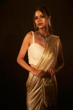 Load image into Gallery viewer, Shop Designer Metallic Shimmer Slit Saree &amp; Embellished Pearl Blouse  for Women Online at Tasuvure. Buy Stylish Nude Saree &amp; attached Palla for Weddings &amp; Events Saia metallic slit saree with an embellished pearl blouse will definitely make you look sassy and elegant in an event. Tailored to perfection in a metallic fabric, the saree features a slit from the waist level and has an attached palla which creates a great fall. It comes with a pearl embellished blouse with dori attachments on the back.